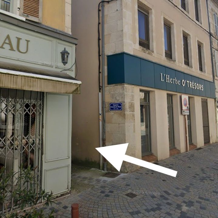 Vue d'une rue avec un bâtiment résidentiel et un accès barré.