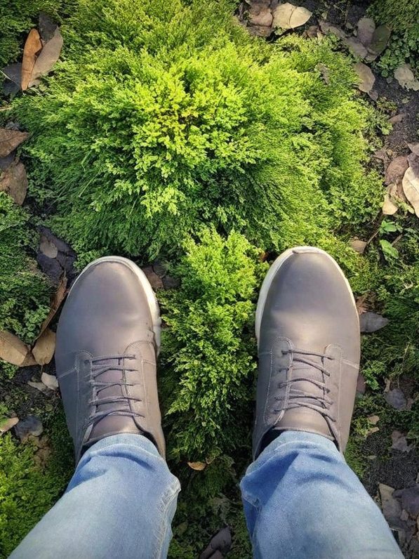 Une paire de chaussures grises sur un sol verdoyant et moelleux.