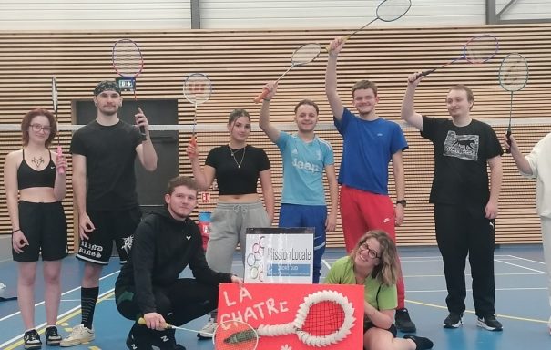 Groupe de joueurs de badminton posant avec des raquettes et un panneau "La Châtre".